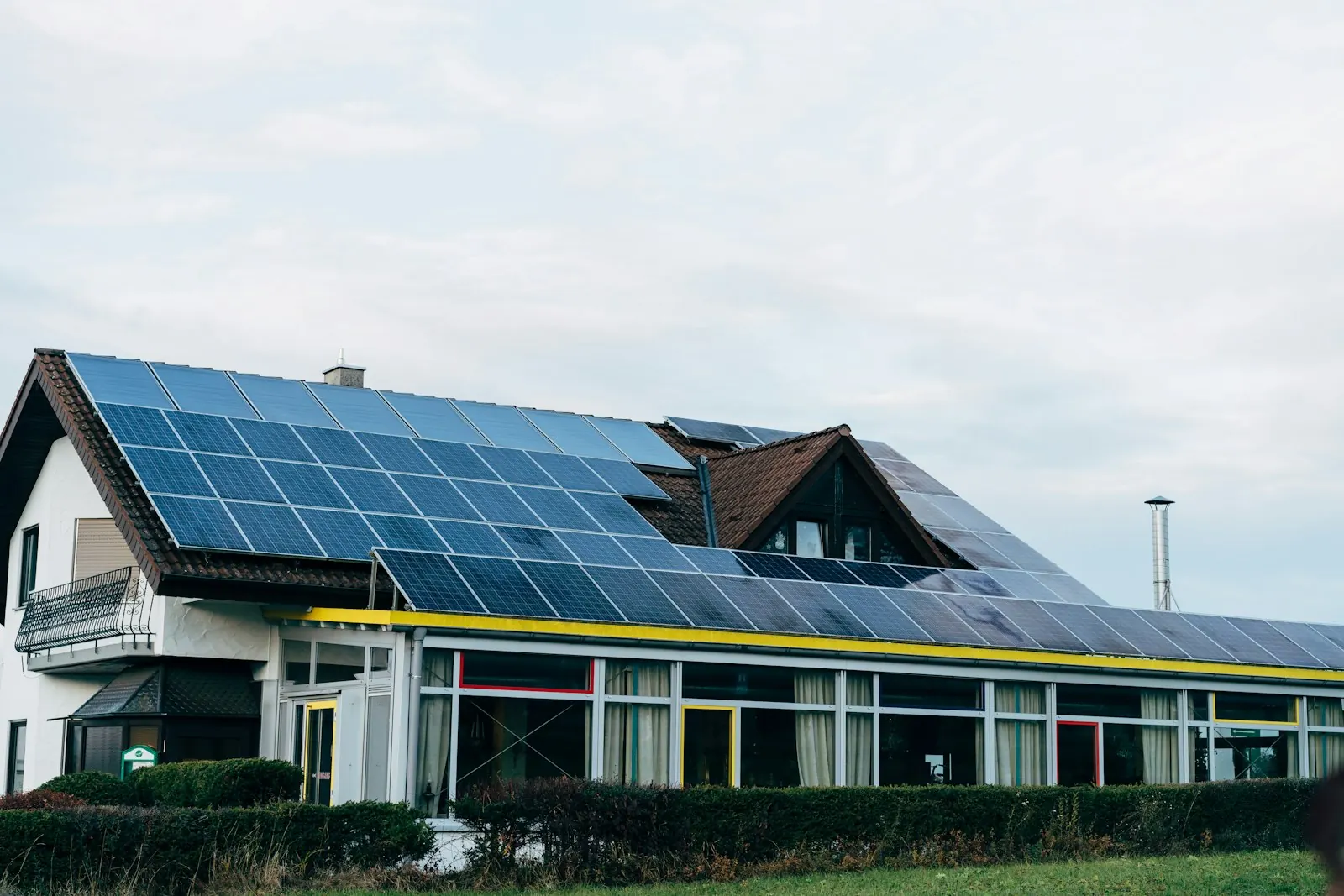 Maison avec véranda et toiture couverte de panneaux solaires